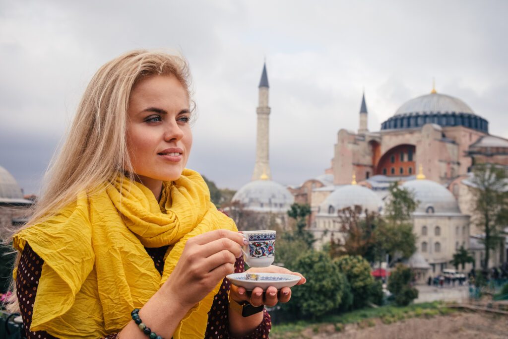 Woman with turkish coffee on Hagia Sophia bacground, Istanbul. Turkey Tours from the USA.