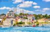Sunny Summer Day in Istanbul: Tourist Ships Adorn Golden Horn Bay with a Breathtaking View of Suleymaniye Mosque and Sultanahmet District Against a Blue Sky and Clouds.