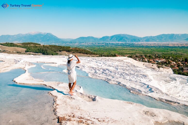 Southwestern Gem: Pamukkale's Natural Travertine Pools and Terraces, the Cotton Castle of Turkey. A Serene Scene: A Girl in a White Dress and Hat Enjoying a Natural Pool at Pamukkale.