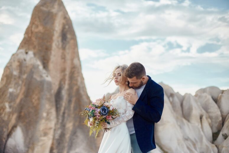 A Loving Embrace: Couple's Affection Amidst Breathtaking Mountain Beauty.