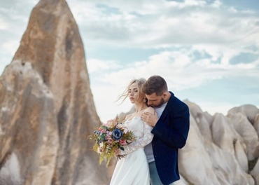 A Loving Embrace: Couple's Affection Amidst Breathtaking Mountain Beauty.